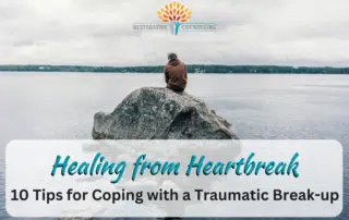 Man in orange jacket sitting on a rock in the middle of a lake healing from heartbreak. end id.