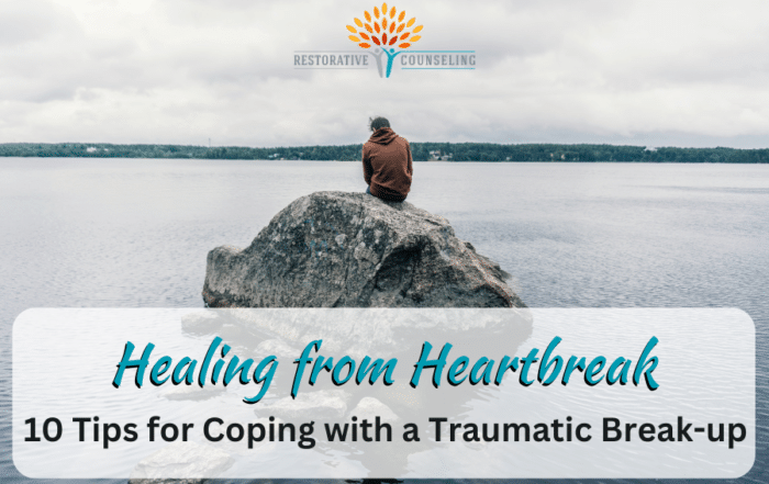 Man in orange jacket sitting on a rock in the middle of a lake healing from heartbreak. end id.